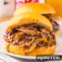Tender Dr Pepper Slow Cooker Pulled Beef 7 Close up looking at an overflowing Crock Pot Dr Pepper Shredded Beef sandwich.
