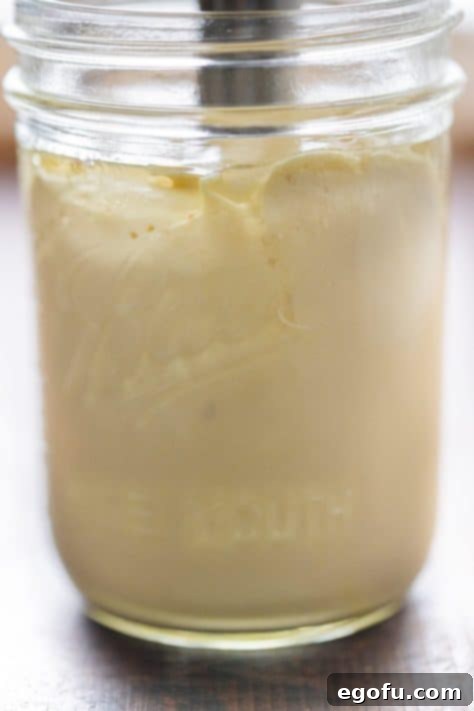 A beautifully finished jar of homemade mayonnaise stands proudly, its creamy texture and fresh appearance promising a delightful culinary experience.