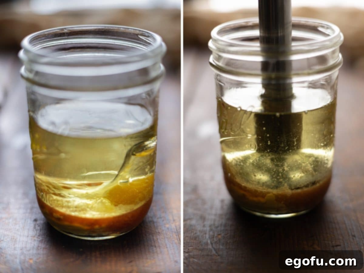 A close-up view of a mason jar with all the ingredients for homemade mayonnaise layered inside, along with an immersion blender poised to begin mixing.