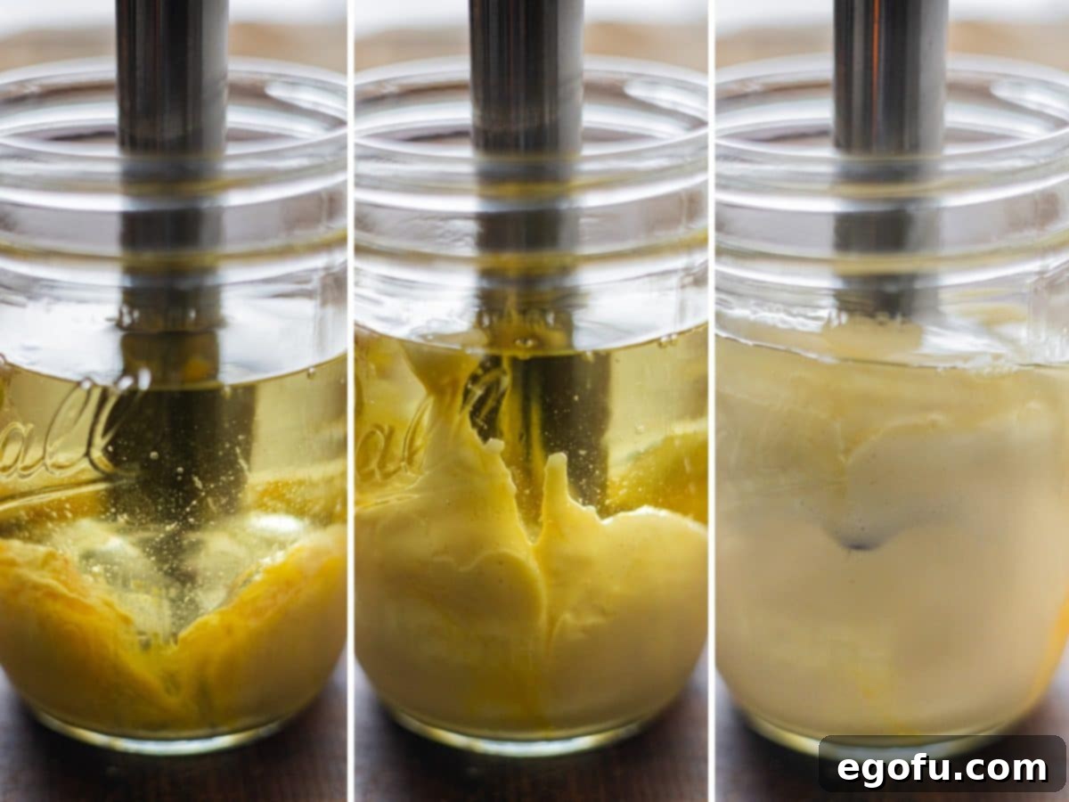 Homemade Mayonnaise being actively mixed in a jar using an immersion blender, showcasing the transformation into a smooth and creamy texture.