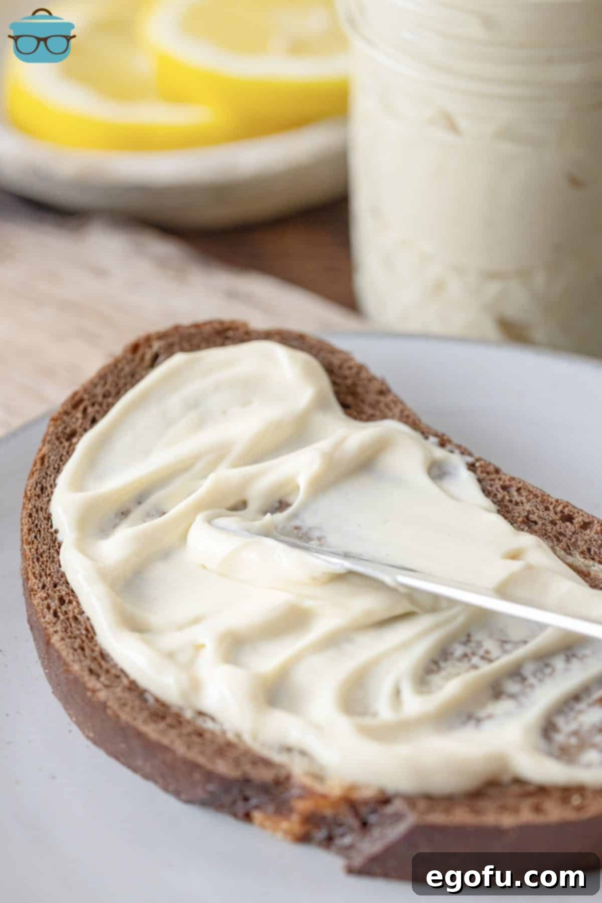A delectable slice of rustic bread generously spread with freshly made Homemade Mayonnaise, perfectly prepared for a delicious sandwich or snack.