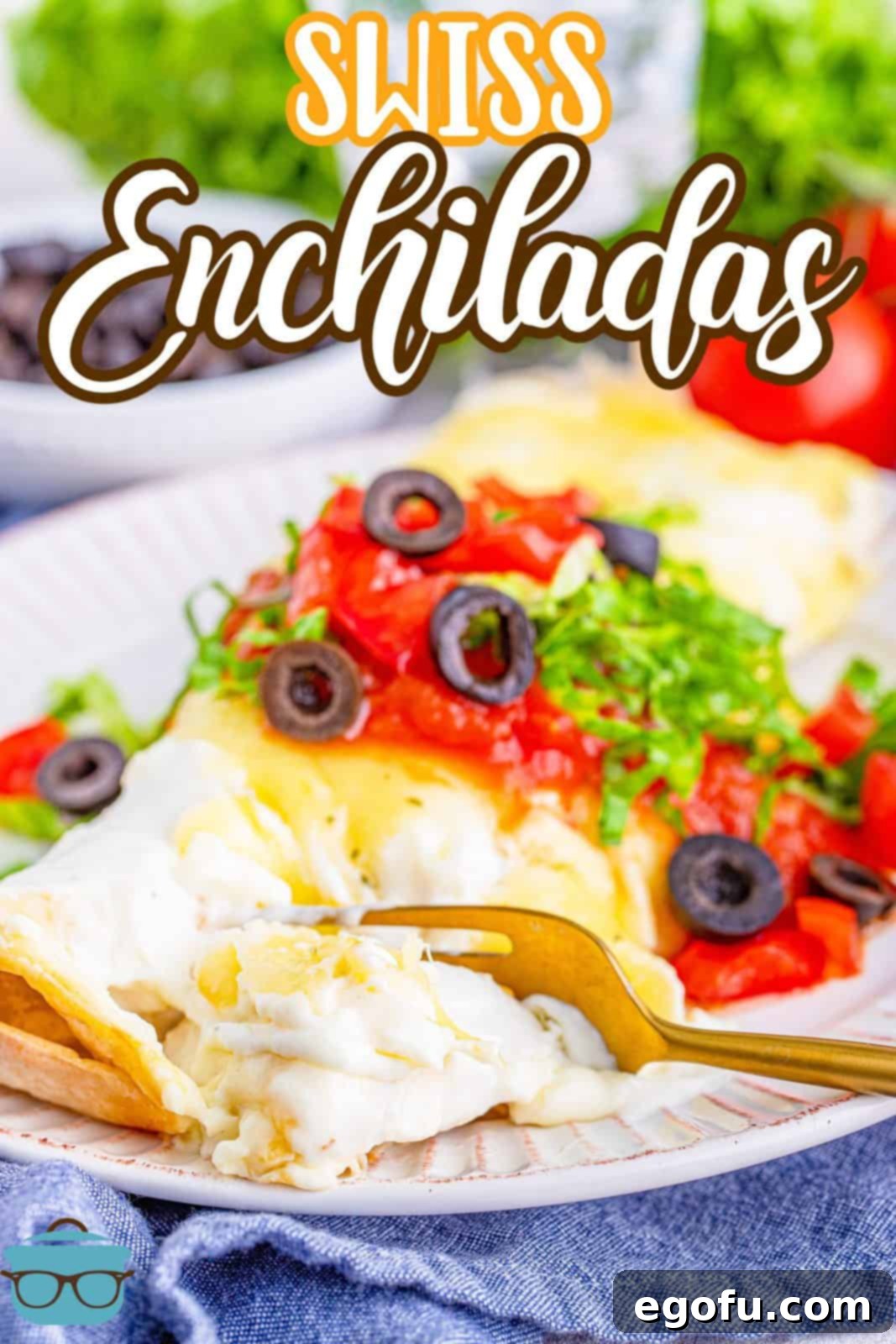 Two Swiss enchiladas on a white plate, garnished with fresh salsa, sliced black olives, and shredded lettuce, with a fork poised to take a bite.