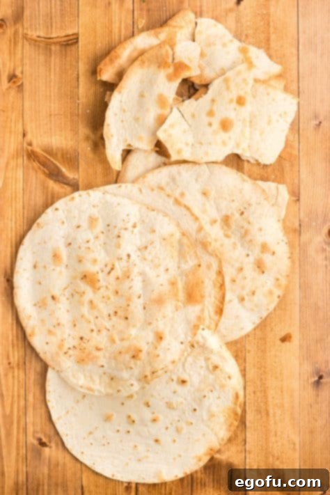 Crispy tortillas on a cutting board, ready to be crumbled for the casserole layers.
