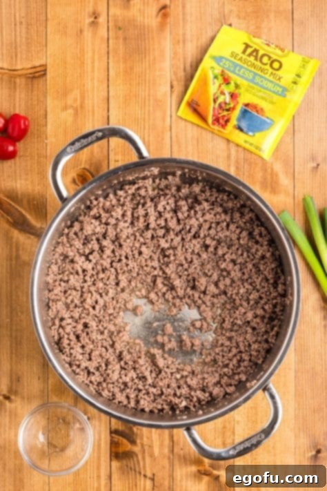 Cooked ground beef in a skillet, drained and ready for seasoning.
