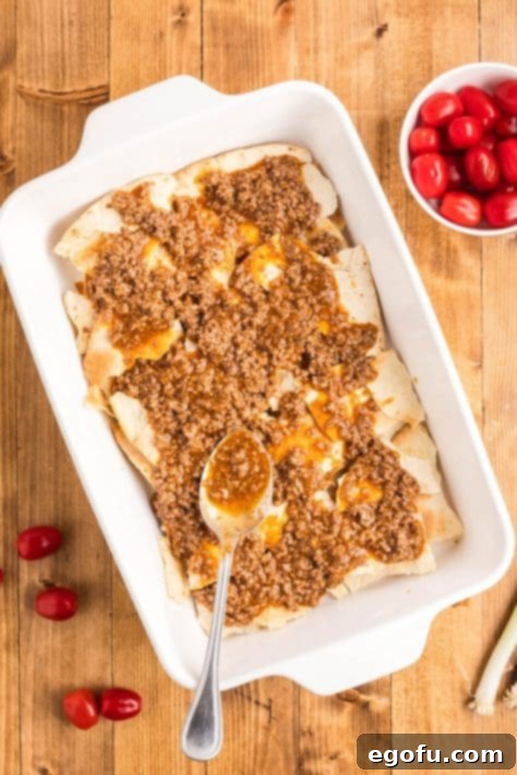 The first meat layer added over the broken tortillas in the casserole dish.
