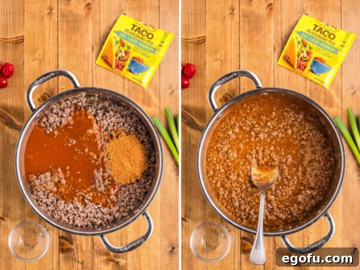 Cooked ground beef simmering with taco seasoning and rich enchilada sauce in a skillet.