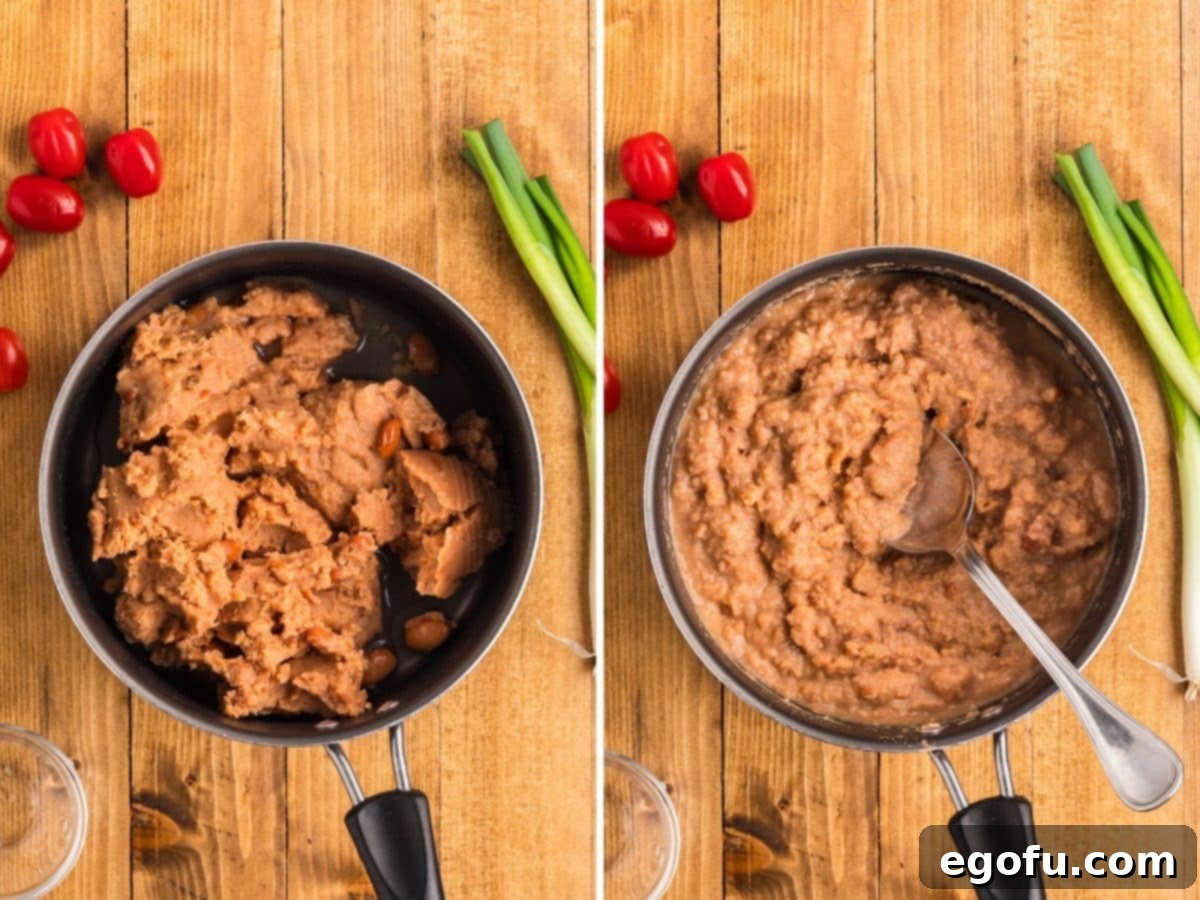 Refried beans and water being heated and stirred in a small pot, creating a smooth, spreadable layer.