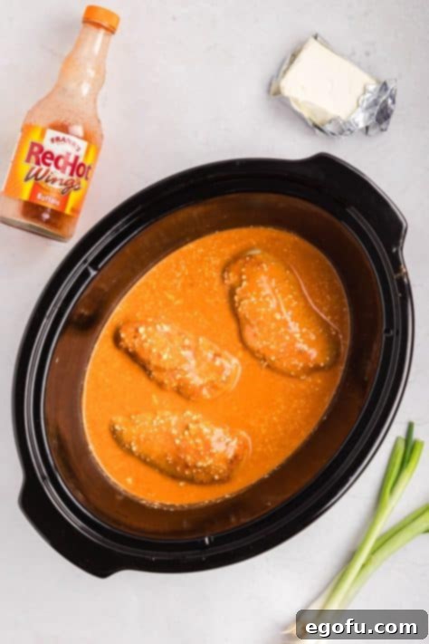 Cooked chicken in a hot sauce in a Slow Cooker.