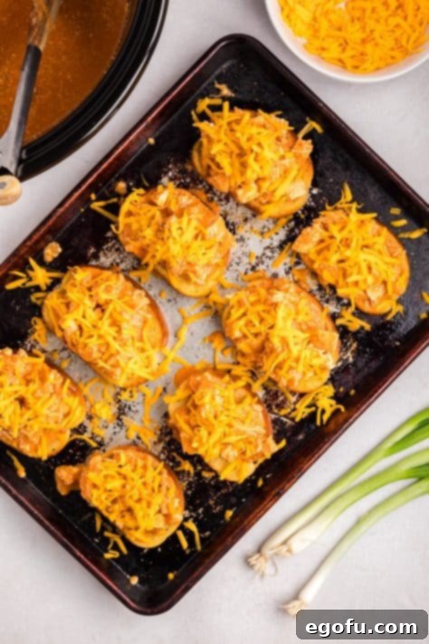 Shredded cheese on top of buffalo chicken on toast.