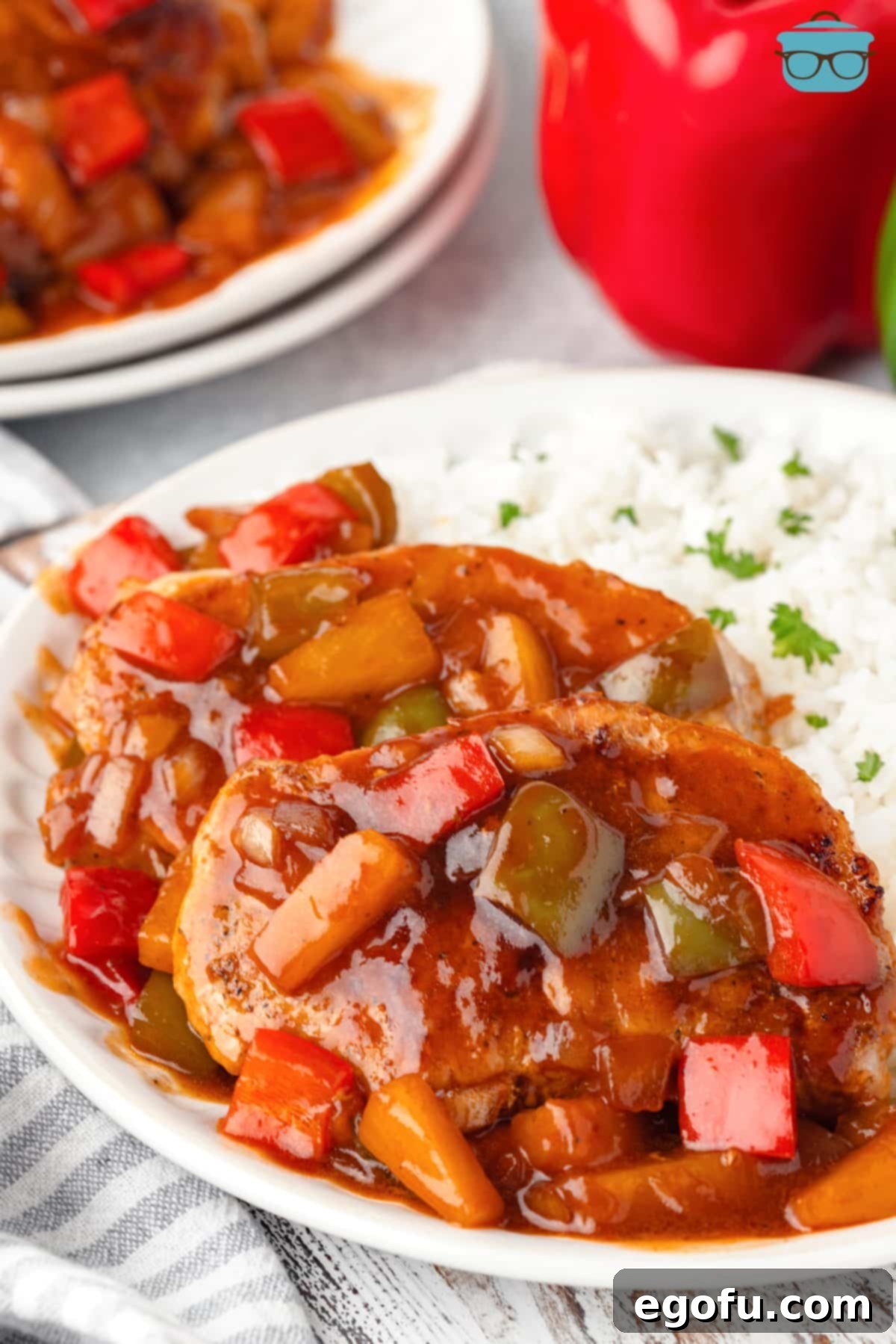 A plate of Sweet and Sour Pork Chops with a side of rice.