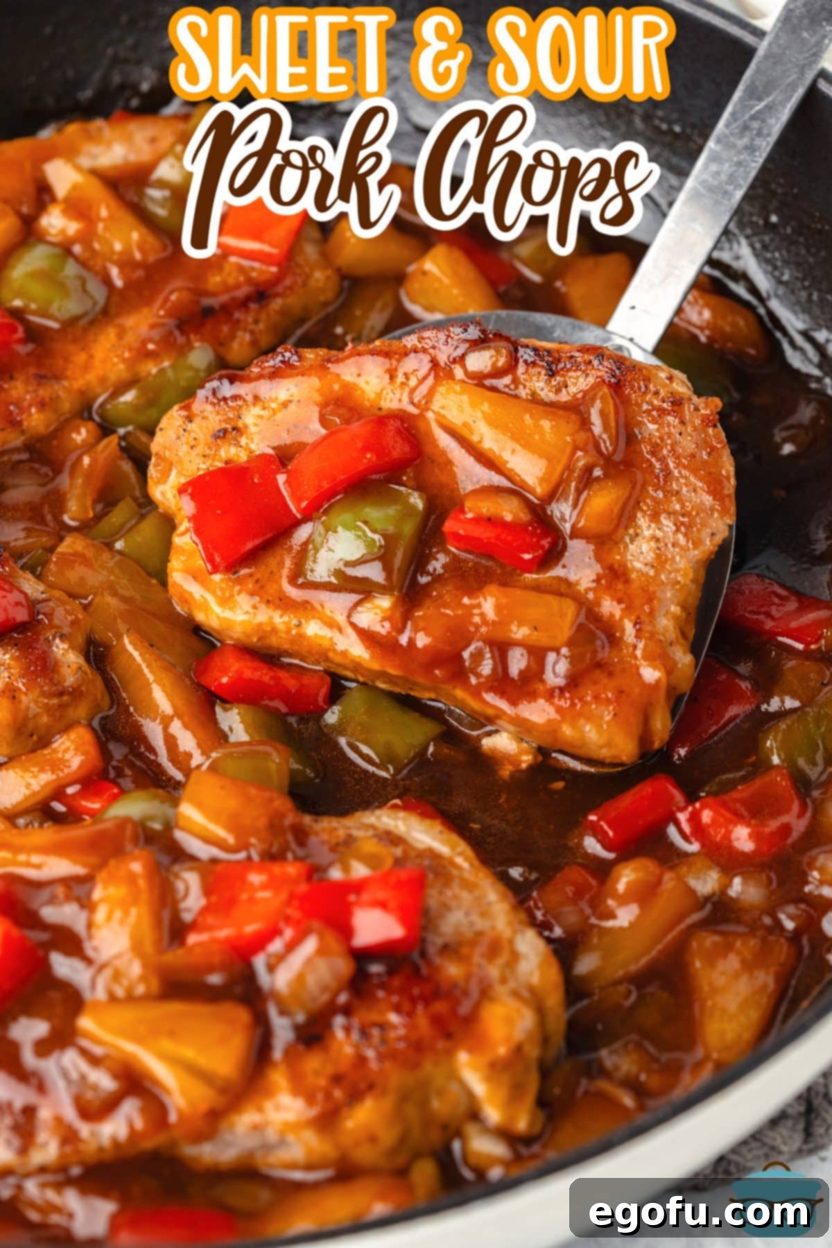 A serving utensil holding a scoop of Sweet and Sour Pork Chops.