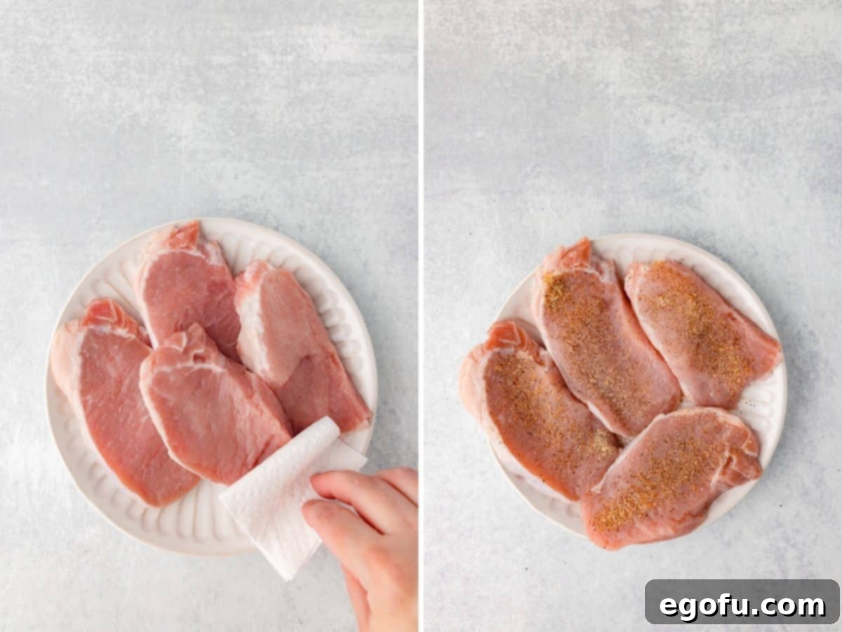 Pork chops being patted dry with paper towels.