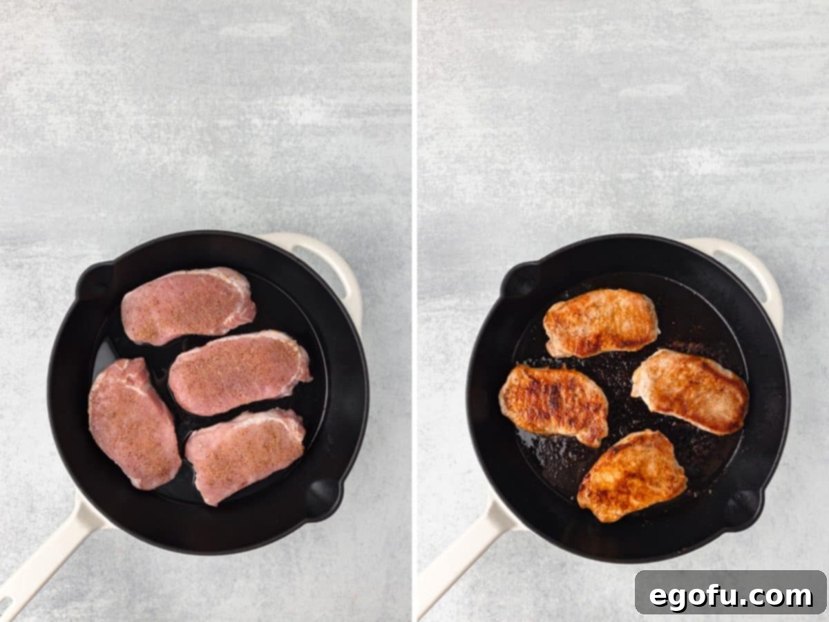 Pork chops being seared in a cast iron skillet.