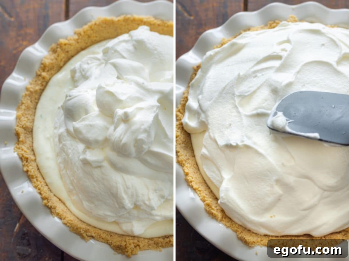 Whipped cream being artfully added and spread across the top of a Key Lime Cream Pie, creating a smooth and appealing layer.