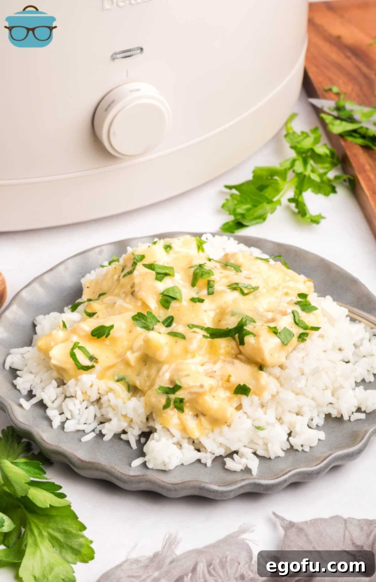 Creamy Ranch Slow Cooker Chicken 2 A plate of Crock Pot Chicken and Ranch on a bed of white rice, garnished with fresh parsley.