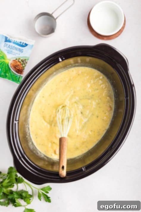 Creamy Ranch Slow Cooker Chicken 10 A crockpot with cream of chicken, chicken stock, milk, and ranch dressing mix being combined.