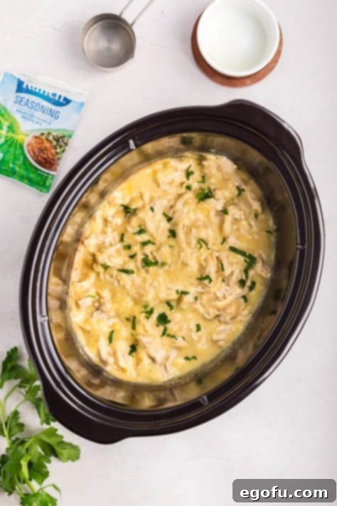Creamy Ranch Slow Cooker Chicken 14 A finished dish of creamy ranch chicken topped with fresh parsley in a slow cooker.