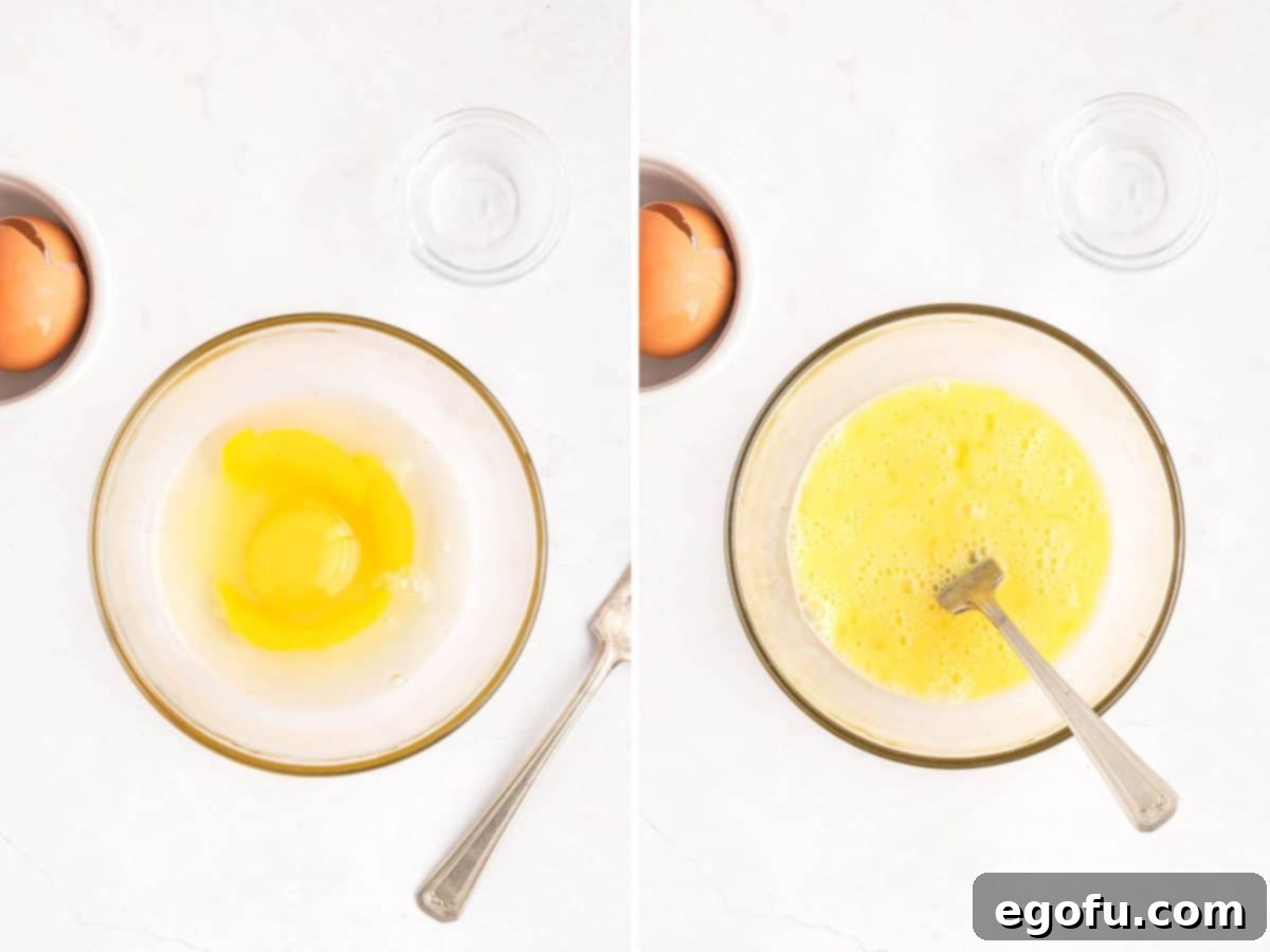 Eggs and water being whisked together with a fork.