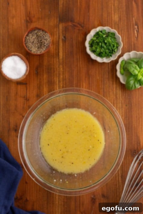 Ingredients for the lemon vinaigrette being whisked in a small bowl.