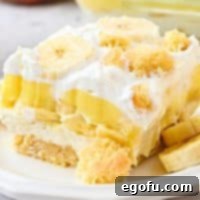 A slice of Banana Pudding Layered Dessert on a dessert plate.