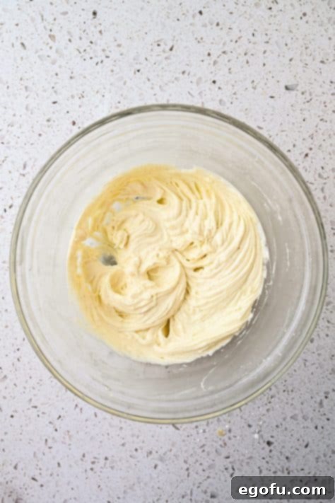Cream cheese mixture being mixed in a bowl.