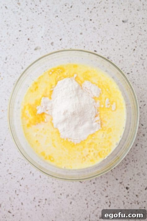 Banana pudding mix and milk being mixed in a bowl.