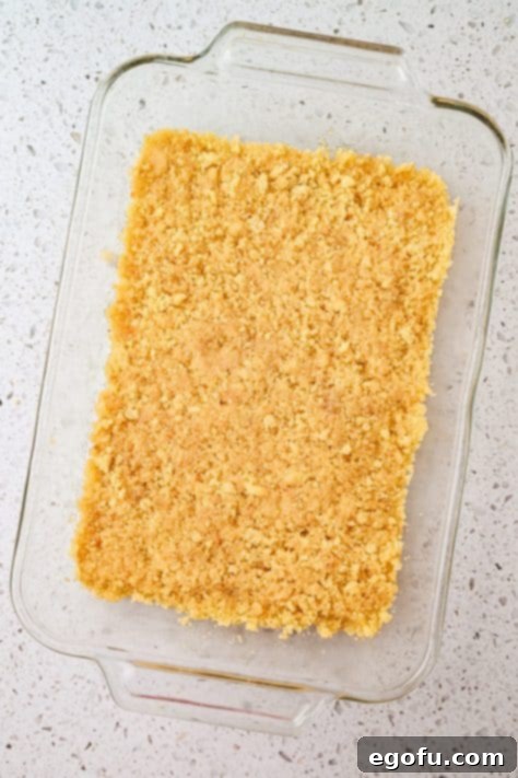 Cookie crumb crust being made in a baking dish.
