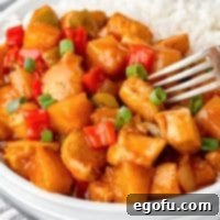 A fork getting a bite of Hawaiian Chicken and rice.