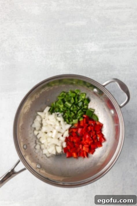 Bell peppers and onions stir-frying in a pan.