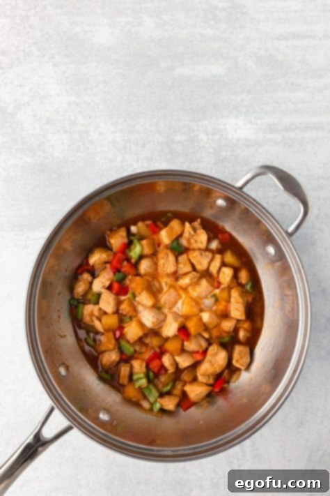 Hawaiian Chicken stir fry with the cornstarch slurry being added to thicken the sauce.