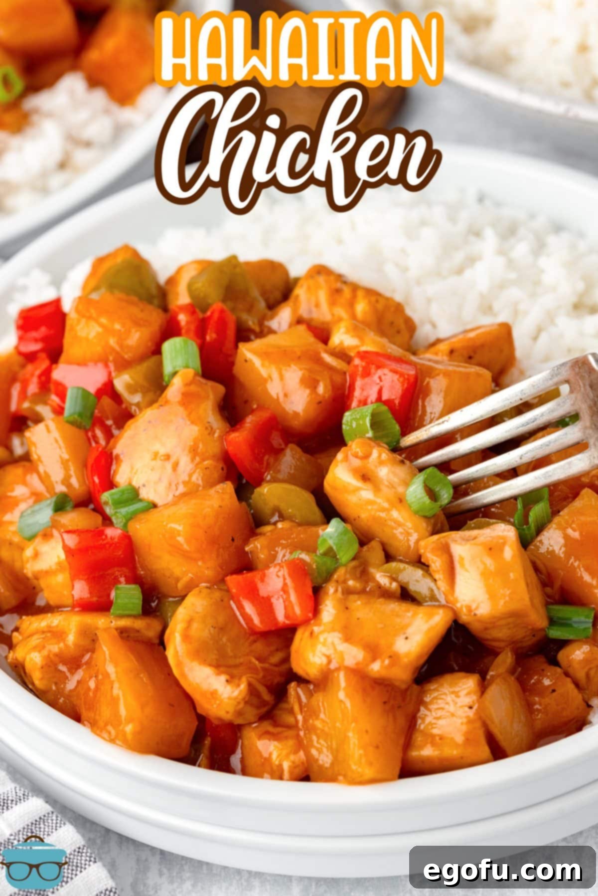 A full serving bowl of white rice and Hawaiian Chicken, ready to be enjoyed with a fork getting a scoop.