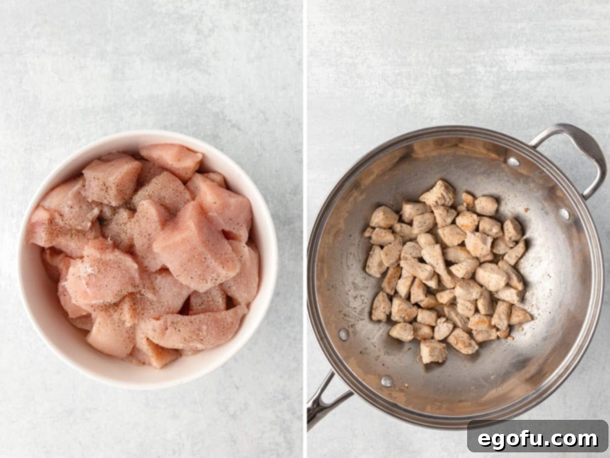 Seasoned chicken breast pieces being cooked to a golden brown in a hot pan.