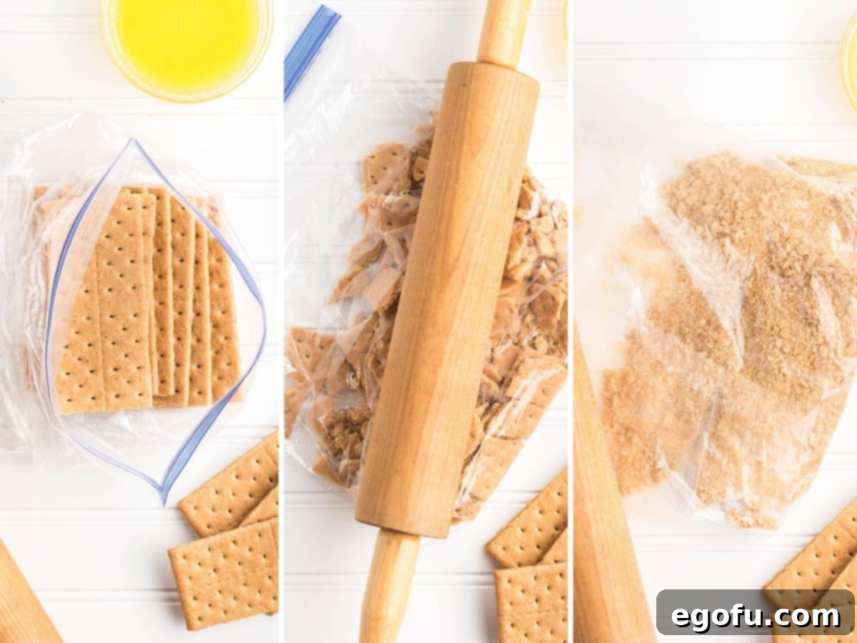 Graham cracker sheets being turned into crumbs in a bag with a rolling pin.