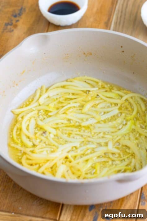 Tender Pork Bites in Rich Gravy 12 Melted butter and sliced onions caramelizing in a skillet, forming the base of the gravy.