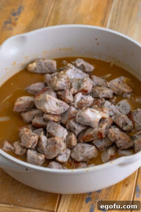 Tender Pork Bites in Rich Gravy 15 Seared pork bites simmering in the homemade gravy within the pot, soaking up the flavors.