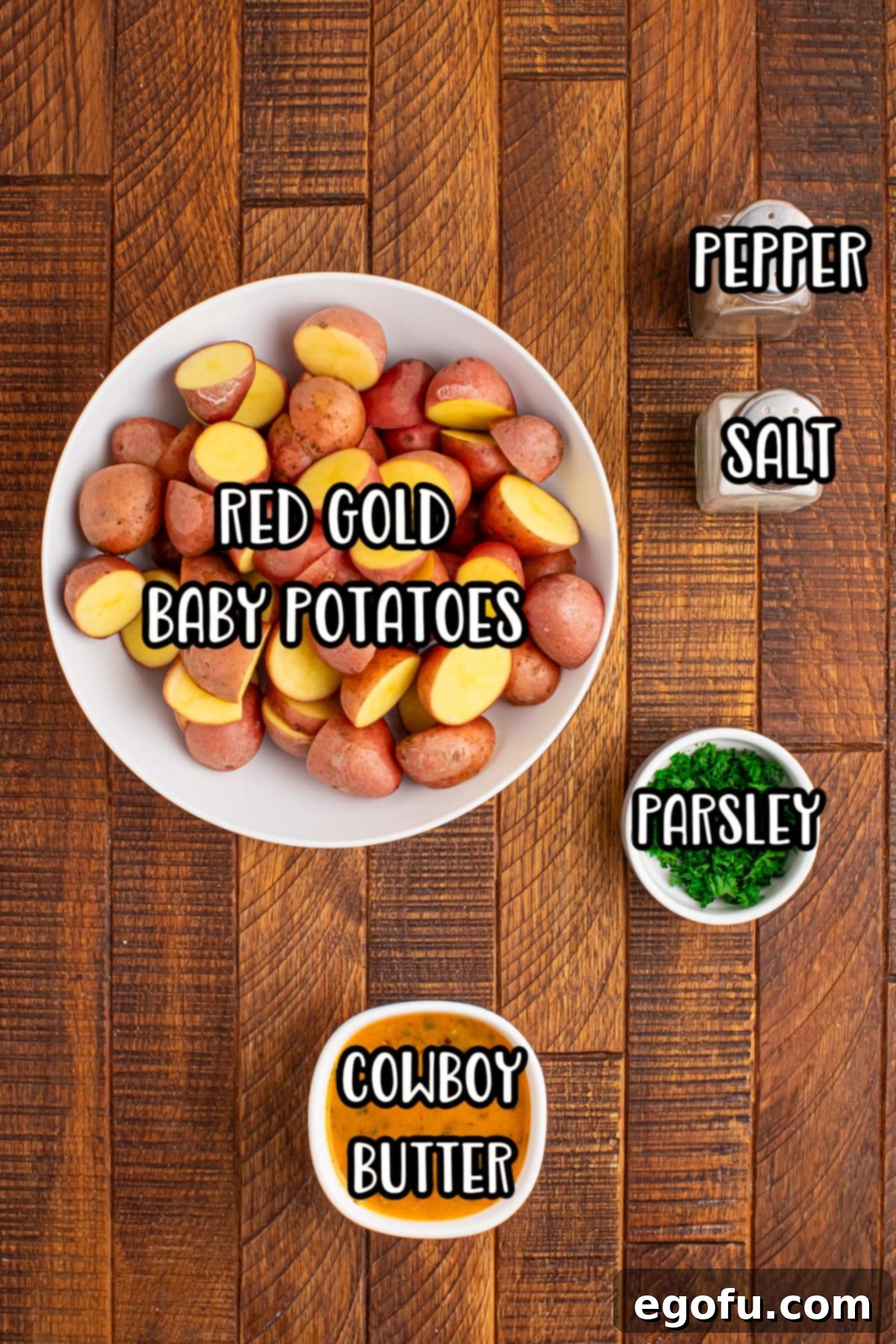 Spicy Garlic Herb Roasted Potatoes 5 Individual ingredients for Cowboy Butter Potatoes including red gold potatoes, a bowl of cowboy butter, salt, pepper, and fresh parsley.