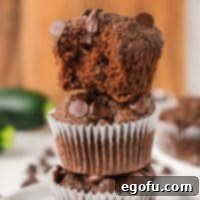 Secretly Healthy Chocolate Zucchini Muffins 8 A Zucchini Chocolate Muffin with one stacked on top missing a bite.