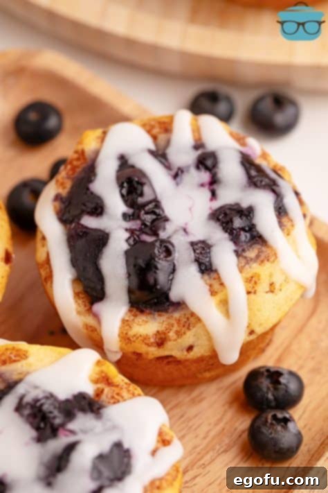 Blueberry Cinnamon Swirl Bites 11 A finished cinnamon roll cup with blueberry pie filling and icing.