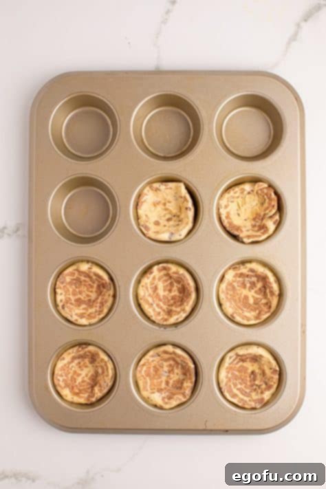 Blueberry Cinnamon Swirl Bites 8 Cinnamon Roll dough being pushed into a muffin tin.