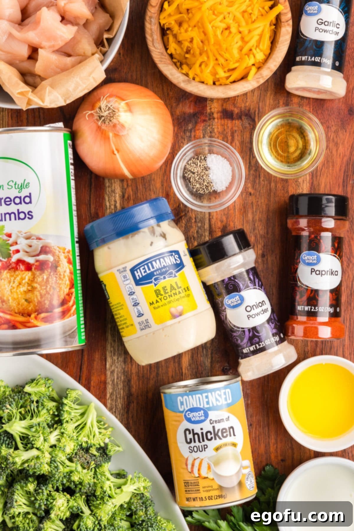 Chicken, mayo, paprika, cream of chicken soup, melted butter, oil, onion, salt, pepper, garlic powder, onion powder, broccoli, milk, shredded cheddar cheese, and breadcrumbs.