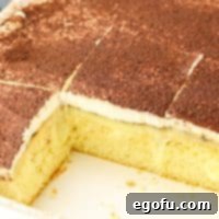 Espresso Kissed Tiramisu Poke Delight 11 Close up looking down on a few slices of Tiramisu Poke Cake in a baking dish.