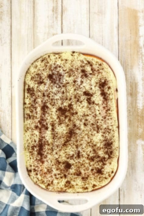 Espresso Kissed Tiramisu Poke Delight 15 Espresso powder coated pudding on a cake.