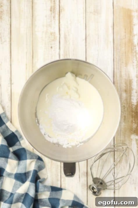 Espresso Kissed Tiramisu Poke Delight 16 Whipped topping being made in a bowl.