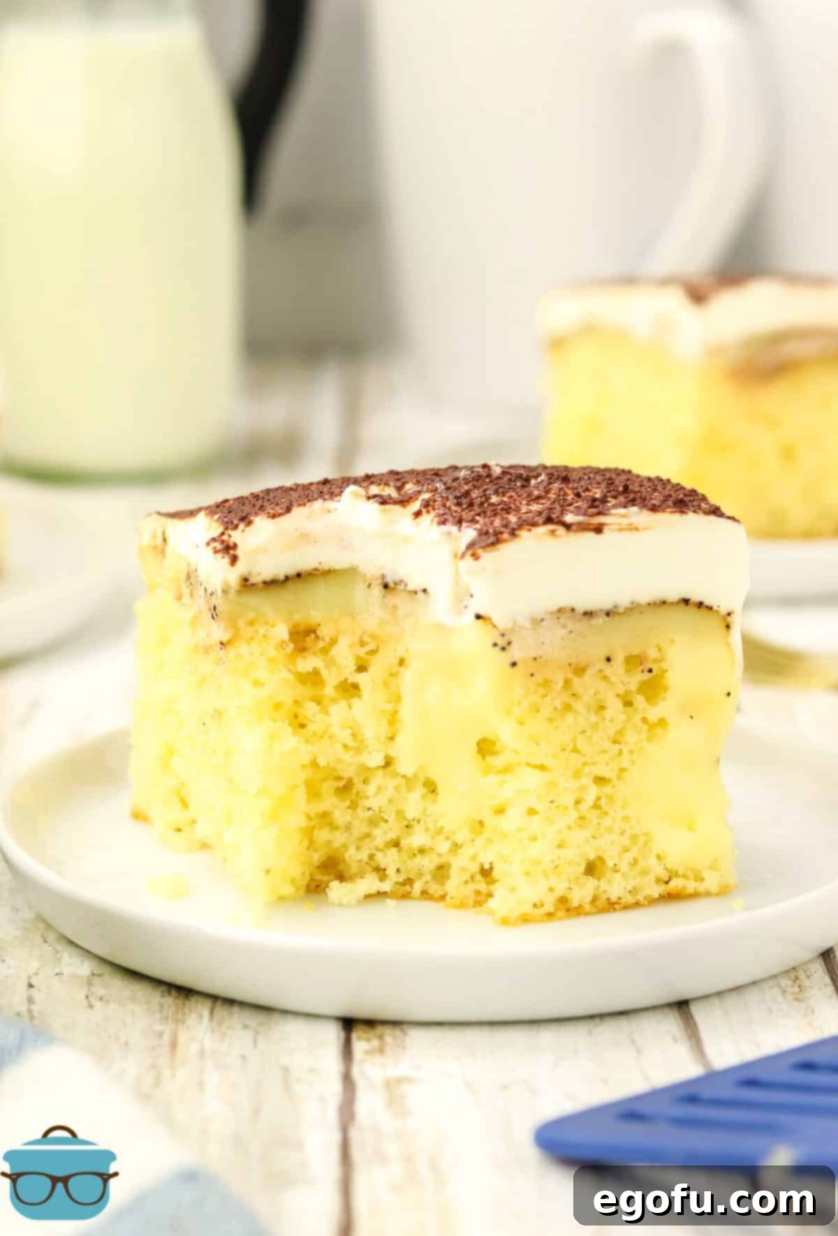 Espresso Kissed Tiramisu Poke Delight 10 A slice of Tiramisu Poke Cake with a bite missing.