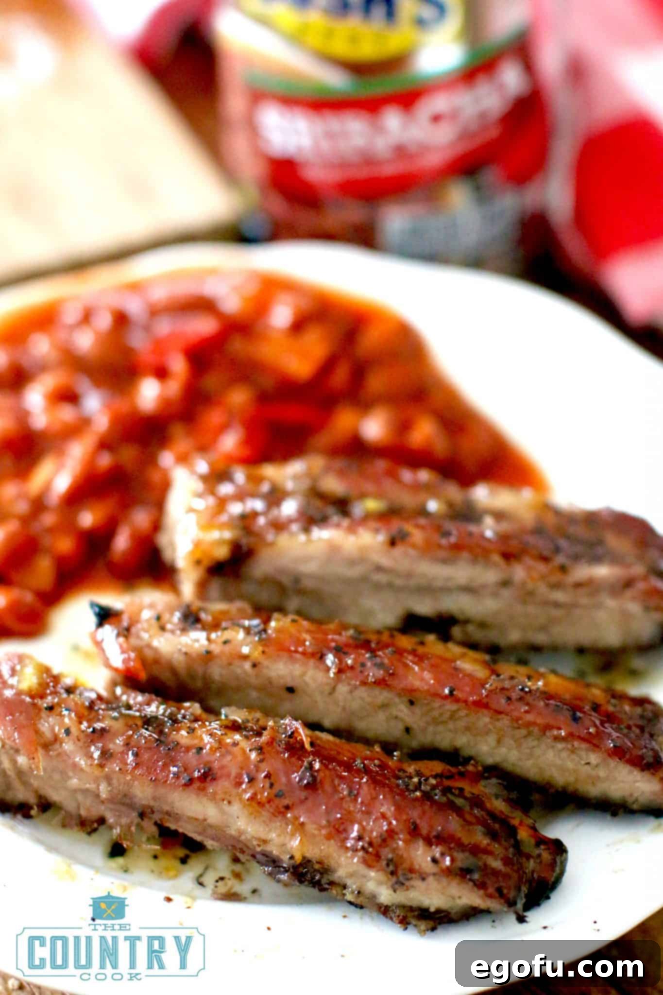 fully cooked rib slices on a plate served with baked beans.