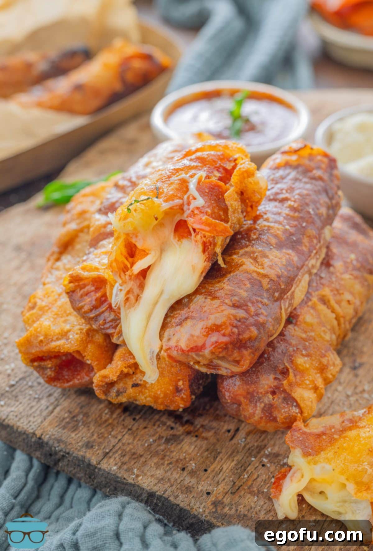 A stack of Disney World copycat Pepperoni Spring Rolls on a serving board.