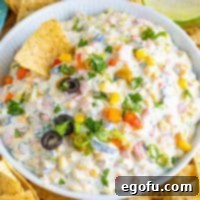 Looking down on a bowl of Poolside Dip with garnishes, featuring a creamy texture and vibrant colors.