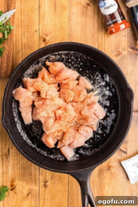 Smoky BBQ Chicken and Crispy Potato Skillet 15 Chicken cooking in a skillet with butter.