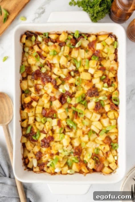 Sliced green onions garnishing Mississippi Mud Potatoes in a baking dish.