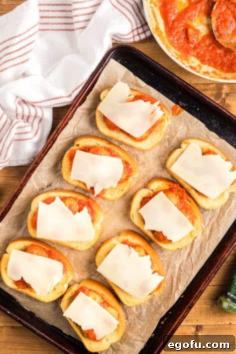 Cheese on top of meatballs with sauce on toast.